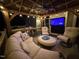 Relaxing outdoor lounge boasts comfortable seating, a built-in grill, and a TV, creating an ideal entertainment space at 6553 Vintage Ridge Ln, Fuquay Varina, NC 27526