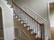 Carpeted staircase with wooden railing and decorative wrought iron balusters at 6553 Vintage Ridge Ln, Fuquay Varina, NC 27526