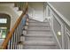 Carpeted staircase with wooden handrail and black iron spindles, leading to the upper level at 6553 Vintage Ridge Ln, Fuquay Varina, NC 27526