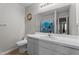 Bathroom with a blue floral shower curtain, white countertop, and a tile flooring, showcasing an ample mirror at 6920 Moss Creek Way, Rocky Mount, NC 27804