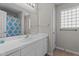 Bathroom with a blue patterned shower curtain, a frosted glass block window, and white countertop at 6920 Moss Creek Way, Rocky Mount, NC 27804