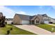 This lovely property includes a spacious driveway, attached garage, and verdant lawn at 6920 Moss Creek Way, Rocky Mount, NC 27804