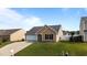 Attractive home featuring an attached garage, well-kept lawn, and appealing tan vinyl siding at 6920 Moss Creek Way, Rocky Mount, NC 27804