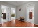 Hallway area with neutral paint color and hardwood flooring that leads to two bedrooms with carpet at 6920 Moss Creek Way, Rocky Mount, NC 27804