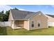 A view of the home's exterior featuring a quaint covered patio and lush green backyard at 6920 Moss Creek Way, Rocky Mount, NC 27804