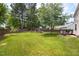 Spacious backyard with a large grassy area, wooden fence, and a fun playset for children to enjoy at 6924 Coventry Ridge Rd, Raleigh, NC 27616