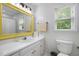 Cozy bathroom with a bright yellow framed mirror above the sink, great natural light, and white cabinets at 6924 Coventry Ridge Rd, Raleigh, NC 27616