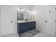 Bright bathroom with a double vanity, large mirror, and stylish lighting fixtures above a hexagon tiled floor at 6924 Coventry Ridge Rd, Raleigh, NC 27616