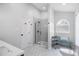 Modern bathroom featuring a glass shower, hexagon tiled floors, and a convenient storage shelf at 6924 Coventry Ridge Rd, Raleigh, NC 27616