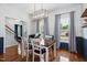 Bright dining room featuring hardwood floors, wainscoting, modern chandelier, and abundant natural light at 6924 Coventry Ridge Rd, Raleigh, NC 27616