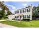 Charming two-story home featuring green shutters and a well-manicured lawn with beautiful flowering shrubs at 6924 Coventry Ridge Rd, Raleigh, NC 27616