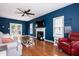 Cozy living room features hardwood floors, a fireplace, ceiling fan, and French doors leading to the backyard at 6924 Coventry Ridge Rd, Raleigh, NC 27616