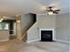Open-concept living room with fireplace, ceiling fan, and staircase at 7331 Bonnie Ridge Ct, Raleigh, NC 27615