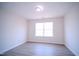 An interior shot of a bedroom with light gray walls and matching wood-look floors and a window at 8021 Wesley Farm Dr, Raleigh, NC 27616