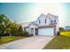 Two-story home featuring stone accents, attached two car garage, and a manicured lawn at 8021 Wesley Farm Dr, Raleigh, NC 27616
