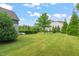Beautifully landscaped backyard featuring a spacious lawn with mature trees and manicured hedges at 900 Green Oaks Pkwy, Holly Springs, NC 27540