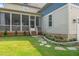 Charming backyard with a screened porch, stone pathway, and colorful flower beds enhancing the home's appeal at 900 Green Oaks Pkwy, Holly Springs, NC 27540