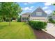 Well-maintained home exterior with a spacious backyard, screened porch, and a three-car garage at 900 Green Oaks Pkwy, Holly Springs, NC 27540