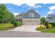 Attractive home exterior showcasing a three-car garage and a lovely backyard with a screened porch at 900 Green Oaks Pkwy, Holly Springs, NC 27540