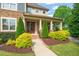 Inviting front entrance featuring a well-manicured garden and a covered porch with stone accents at 900 Green Oaks Pkwy, Holly Springs, NC 27540