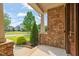 Covered front porch with stone wall, wooden door, and neatly trimmed landscaping at 900 Green Oaks Pkwy, Holly Springs, NC 27540