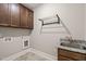 Functional laundry room featuring custom cabinets, a sink, and a tile floor at 900 Green Oaks Pkwy, Holly Springs, NC 27540