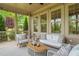 Comfortable screened porch featuring a ceiling fan and stylish outdoor furniture with a view of the landscaped backyard at 900 Green Oaks Pkwy, Holly Springs, NC 27540