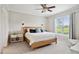 Comfortable bedroom with a wood frame bed, ceiling fan, and natural light from the window at 9300 Lake Wheeler Rd, Fuquay Varina, NC 27526