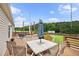 Large wooden deck with a dining table, lounge furniture, and scenic backyard views at 9300 Lake Wheeler Rd, Fuquay Varina, NC 27526