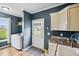 Well-organized mudroom with a laundry machine, sleek cabinets, and access to the outdoors offers convenience at 9300 Lake Wheeler Rd, Fuquay Varina, NC 27526