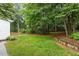 Lush backyard featuring manicured lawn, green trees, and lovely landscaping at 9425 Brimstone Ln, Raleigh, NC 27613