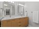 Bathroom featuring double sinks, modern fixtures, wood cabinets, and two mirrors at 9425 Brimstone Ln, Raleigh, NC 27613