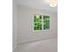 Bright, neutral bedroom with gray carpet, white trim, and window with green view at 9425 Brimstone Ln, Raleigh, NC 27613