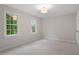 Bright, neutral bedroom with gray carpet, white trim, and two windows at 9425 Brimstone Ln, Raleigh, NC 27613