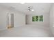 Spacious bedroom with plush gray carpet, a ceiling fan, and natural light from the windows at 9425 Brimstone Ln, Raleigh, NC 27613