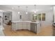 Stylish kitchen island features white cabinets, stainless steel appliances, hardwood flooring and modern pendant lighting at 9425 Brimstone Ln, Raleigh, NC 27613
