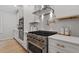 Modern kitchen with a stainless steel hood and oven range plus light stone countertops at 9425 Brimstone Ln, Raleigh, NC 27613