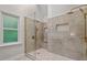 Modern bathroom shower featuring gray tile, bench, dual shower heads, and built-in niche at 9425 Brimstone Ln, Raleigh, NC 27613