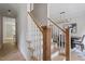 Elegant staircase with wooden handrail and white balusters leading to the upper level at 9425 Brimstone Ln, Raleigh, NC 27613