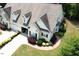 Charming, light-yellow home featuring a two-car garage, dormer windows, and beautifully landscaped front yard at 100 Sheraton Ln, Garner, NC 27529