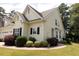 Inviting home with yellow siding, black shutters, manicured landscaping, and charming architectural details at 100 Sheraton Ln, Garner, NC 27529