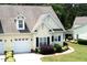 Attractive home with a two-car garage, dormer windows, and dark shuttered windows surrounded by landscaping at 100 Sheraton Ln, Garner, NC 27529