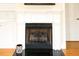 Classic white fireplace with black grate and decorative trim, set against hardwood floors and white walls at 100 Sheraton Ln, Garner, NC 27529