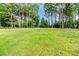 Expansive green backyard, bordered by mature trees, offering privacy and space at 104 Crosby Ln, Sanford, NC 27330