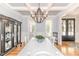 Elegant dining area with hardwood floors, trey ceiling, stylish lighting, and a large china cabinet at 104 Crosby Ln, Sanford, NC 27330