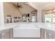 Kitchen island featuring a farmhouse sink with quartz countertops, stainless steel appliances and open view to the living room at 104 Crosby Ln, Sanford, NC 27330