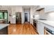 Bright kitchen features a stainless steel refrigerator, white cabinets, hardwood floors and access to the outdoors at 104 Crosby Ln, Sanford, NC 27330