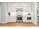 Kitchen with stainless steel appliances, quartz countertops, white cabinets and hardwood floors at 104 Crosby Ln, Sanford, NC 27330