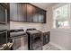 Well-equipped laundry room featuring modern appliances and sleek, dark cabinetry at 104 Crosby Ln, Sanford, NC 27330