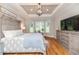 Bright main bedroom with hardwood floors, a decorative ceiling, and large windows providing ample natural light at 104 Crosby Ln, Sanford, NC 27330